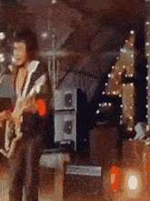 a man singing into a microphone while holding a guitar