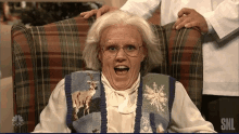 a woman is sitting in a chair with a snl logo on the bottom