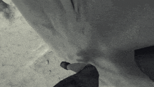 a black and white photo of a person standing on a ledge