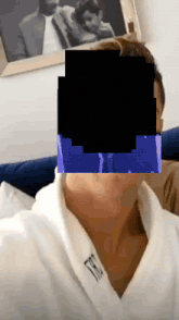 a person wearing a white robe with the letter t on the collar