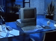 a computer monitor sits on a glass desk