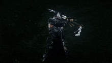 a person in a futuristic suit is holding a sword in a dark room .