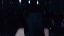 a woman in a black dress is dancing in front of a crowd of people