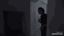 a woman stands in a dark room with the words made in animotica on the bottom right