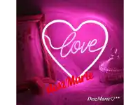 a heart shaped neon sign that says love
