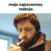 a man with a beard is lighting a cigarette with a lighter