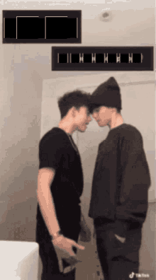a couple of men standing next to each other with a tiktok logo on the bottom