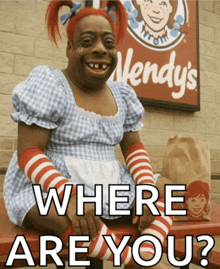 a wendy 's sign is behind a woman in a wendy 's outfit
