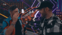 two men shake hands on a stage with rtve written on the bottom