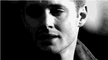 it is a black and white photo of a man 's face .