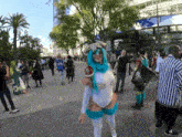 a woman in a blue and white costume is standing in a crowd