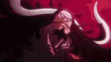 a man with long horns is standing in the dark .