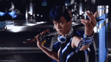 a man holding a sword with the words dryedmangoez.com on the bottom right