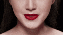 a close up of a woman 's face with red lipstick on her lips