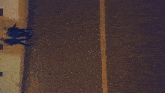 a car is parked on the side of the road next to a brick wall