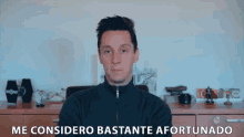 a man stands in front of a sign that says me considero bastante afortunado