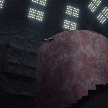 a person is standing in front of a large red sphere with the number 16 on it
