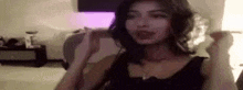 a woman is wearing headphones and making a funny face while sitting on a bed .