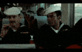 a man wearing a sailor hat sits in a bus
