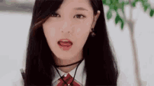 a close up of a girl with long black hair wearing a choker and a school uniform .