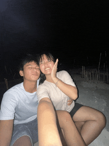 a boy and a girl are posing for a picture and the girl is smiling