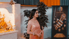 a woman in a pink saree stands in front of a sign that says ' awards '