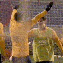 a soccer player wearing a beko jersey holds up his arms in the air