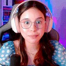 a woman wearing glasses and headphones is looking at the camera