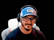 a man wearing headphones and a blue hat with a patch that says flying tigers