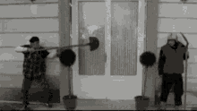 two men are holding shovels in front of a door .