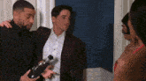 a man in a suit is holding a bottle of champagne while standing next to a woman .