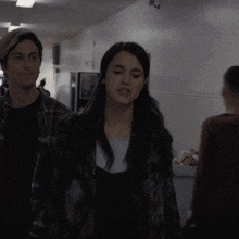 a man and woman are walking down a hallway