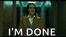 a man in a suit is walking down a hallway with the words `` i 'm done '' written on the bottom .