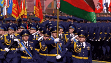 a group of soldiers marching in a parade with flags including one that says ' ukraine ' on it