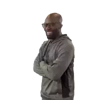 a man with his arms crossed is wearing a grey hoodie