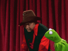 a man in a cowboy hat is holding a rat puppet