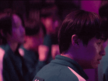 a man in a green shirt with the letter k on the back looks down