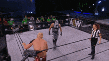 a wrestler in a ring with a sign that says aew
