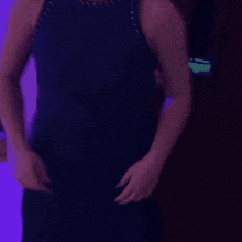 a woman in a blue dress is standing in a dark room