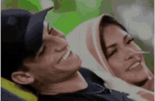 a man and a woman are smiling and looking at the camera