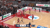 a basketball game is being played in front of a crowd and the score is 3 to 6