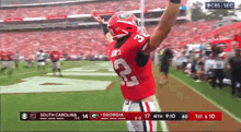 a football player with the number 32 on his jersey stands on the field