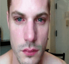 a close up of a man 's face with tears running down his eyes