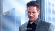 a man in a suit says come on