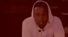 a man wearing a white hoodie with the name kendrick lamar on the front
