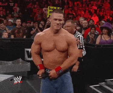 a shirtless wrestler is standing in front of a crowd with a sign that says ' scala ' on it