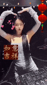 a woman making a heart shape with her hands in front of a chinese symbol