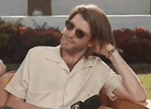 a man wearing sunglasses is sitting in a chair