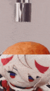 a stuffed animal is sitting on a table next to an orange and a metal object .