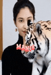 a woman holding a stuffed tiger with the word manis on the bottom right